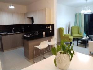 a kitchen with green chairs and a living room at Moderno Apartamento amueblado Full 3 habitaciones, wifi, Netflix in Santiago de los Caballeros