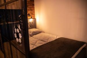 a small bedroom with a bed and a lamp at Warsztat SAUNA&JACUZZI in Poronin