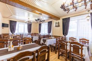 un restaurante con mesas, sillas y ventanas en У Румуна, en Yasinya