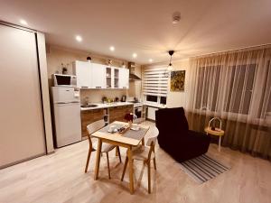 a kitchen and living room with a table and chairs at Apartment128 in Valmiera