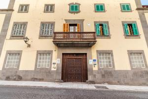 um edifício com uma varanda e uma porta de madeira em Flatguest RoomTiques Private Rooms em Las Palmas de Gran Canaria