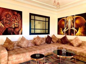 - un salon avec un canapé et deux peintures murales dans l'établissement Sab 9 - Great View Over Hassan Mosque. Luxurious 3 Bedrooms & 2,5 Bathrooms, à Casablanca