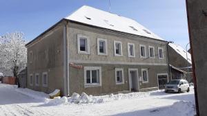 a building with a car parked in the snow at chalupa in Hora Svatého Šebestiána