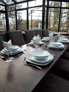 a long wooden table with plates and wine glasses at Lakeview in Keerbergen
