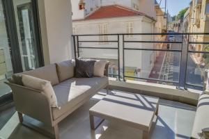 ein Sofa auf einem Balkon mit Stadtblick in der Unterkunft IMMOGROOM- Modern - Elegant - Close to the beach -AC in Cannes