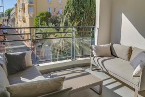 einen Balkon mit Sofas und Straßenblick in der Unterkunft IMMOGROOM- Modern - Elegant - Close to the beach -AC in Cannes