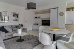 ein Wohnzimmer mit einem Sofa, einem Tisch und Stühlen in der Unterkunft IMMOGROOM- Modern - Elegant - Close to the beach -AC in Cannes