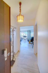 un couloir avec un lustre et un salon dans l'établissement IMMOGROOM -Panoramic sea view terrace-2min from the beach, à Cannes