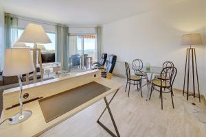 - un salon avec une table et des chaises dans l'établissement IMMOGROOM -Panoramic sea view terrace-2min from the beach, à Cannes