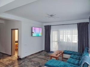 a living room with a blue couch and a table at Mountain Break Azuga in Azuga