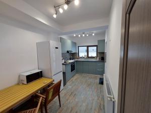 a kitchen with a table and a refrigerator at Mountain Break Azuga in Azuga