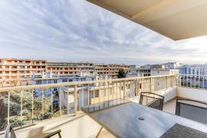 d'un balcon avec une table et une vue sur la ville. dans l'établissement IMMOGROOM - Renovated apartment - Terrace - AC - Wifi, à Cannes