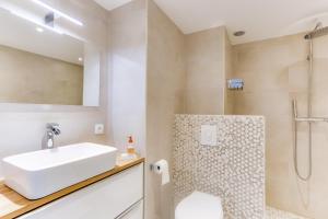 La salle de bains blanche est pourvue d'un lavabo et d'une douche. dans l'établissement IMMOGROOM - Renovated apartment - Terrace - AC - Wifi, à Cannes