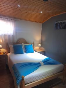 a bedroom with a large bed with blue pillows at Casa Pelourinho in Gouveia