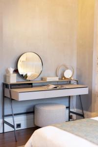 a bedroom with a desk with a mirror at Castellano Hotel & Suites in Nafplio