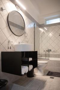 a bathroom with a sink and a toilet and a mirror at Petrino Suites Mesolonghi in Missolonghi