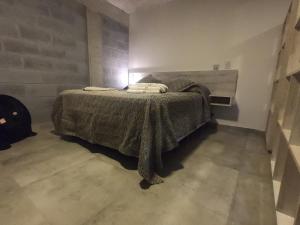 Un dormitorio con una cama con una manta. en Trastolillo Villa Gesell en Villa Gesell