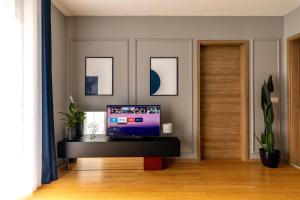 a living room with a tv on a table at Etern Stays - Urban Apartment in Pristina