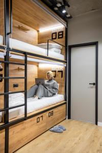 a man sitting on a bunk bed with a laptop at VIA Hostel in Kazan