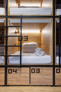 カザンにあるVIA Hostelの二段ベッド(白いシーツ付)が備わる客室です。