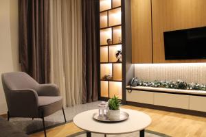 a living room with a couch and a chair and a table at Modern mountain - Crown apartment in Kolašin