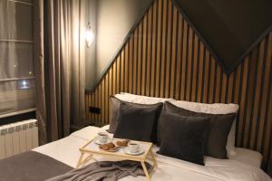 Una cama con cabecero de madera y una mesa con tazas. en Modern mountain - Crown apartment en Kolašin