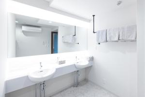a white bathroom with two sinks and a mirror at RESIDENCE HARIMAYA-Vacation STAY 99860v in Kochi