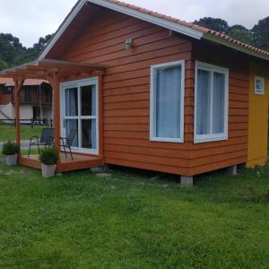 a small house with a porch and a patio at Pousada caminhos do mel in Urubici