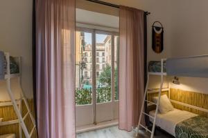 1 dormitorio con literas y ventana grande en Social - Coliving & Coworking - Madrid, en Madrid
