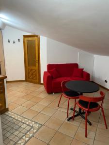 ein Wohnzimmer mit einem roten Sofa und einem Tisch in der Unterkunft Frascati Roof 2 in Frascati
