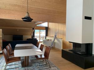 een woonkamer met een tafel en een open haard bij CHALET Mitoyen LE RUSTICANA in Chamonix-Mont-Blanc