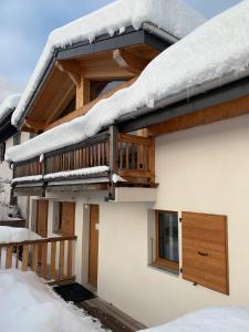 um telhado coberto de neve de uma casa com uma varanda em CHALET Mitoyen LE RUSTICANA em Chamonix-Mont-Blanc