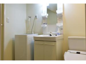 a bathroom with a sink and a mirror and a toilet at Alphabed Takamatsu Furujinmachi - Vacation STAY 11905 in Takamatsu