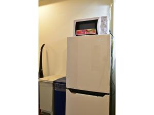 a refrigerator with a microwave on top of it at Alphabed Takamatsu Furujinmachi - Vacation STAY 11905 in Takamatsu