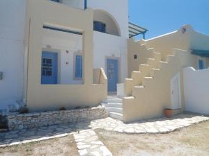 a white house with white stairs and blue doors at Anastasia in Aliko Beach