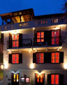 budynek z czerwonymi drzwiami i oknami w nocy w obiekcie Pension Eleni w Nauplionie