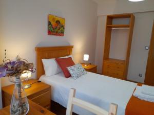 a bedroom with a bed and a table with a vase of flowers at Apartamento Portugalete Gran Bilbao 3 dormitorios - 3 bedrooms in Portugalete
