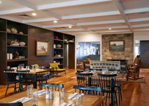 Salado的住宿－Stagecoach Inn，一间带桌椅和壁炉的用餐室