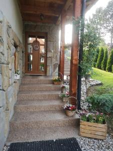 eine Eingangstür eines Hauses mit einer Steinmauer in der Unterkunft Pokoje gościnne Zosia in Kościelisko