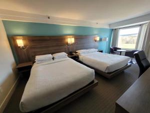Łóżko lub łóżka w pokoju w obiekcie Manoir des Sables Hôtel & Golf