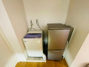 - un petit réfrigérateur dans l'angle de la chambre dans l'établissement Cube Haruyoshi Patio - Vacation STAY 92593v, à Fukuoka