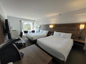 Łóżko lub łóżka w pokoju w obiekcie Manoir des Sables Hôtel & Golf