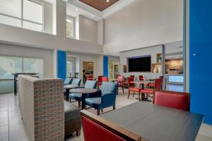 a restaurant with tables and chairs and a tv at Holiday Inn Express Hotel & Suites Lufkin South, an IHG Hotel in Lufkin