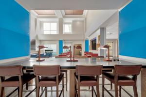 a lobby with chairs and a bar with blue walls at Holiday Inn Express Hotel & Suites Lufkin South, an IHG Hotel in Lufkin