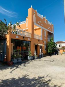 Pousada Krolow في بيلوتاس: مبنى برتقالي كبير أمامه نباتات