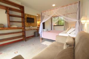 um quarto com uma cama, uma cama e um sofá em Pousada Rosa 08 em Praia do Rosa