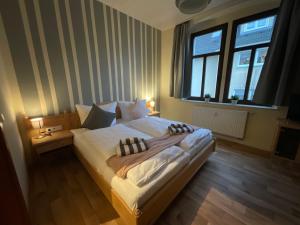 um quarto com uma cama grande e uma janela em Pension Lindenhof em Dresden