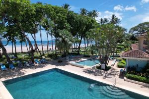 eine Luftansicht auf einen Pool und den Strand in der Unterkunft Hotel Tamarindo Diria Beach Resort in Tamarindo