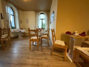 uma sala de jantar com cadeiras, uma mesa e um lavatório em Pension Lindenhof em Dresden