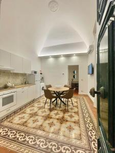 a kitchen with a table, chairs and a refrigerator at Palazzo Bianchi - Trani in Trani
